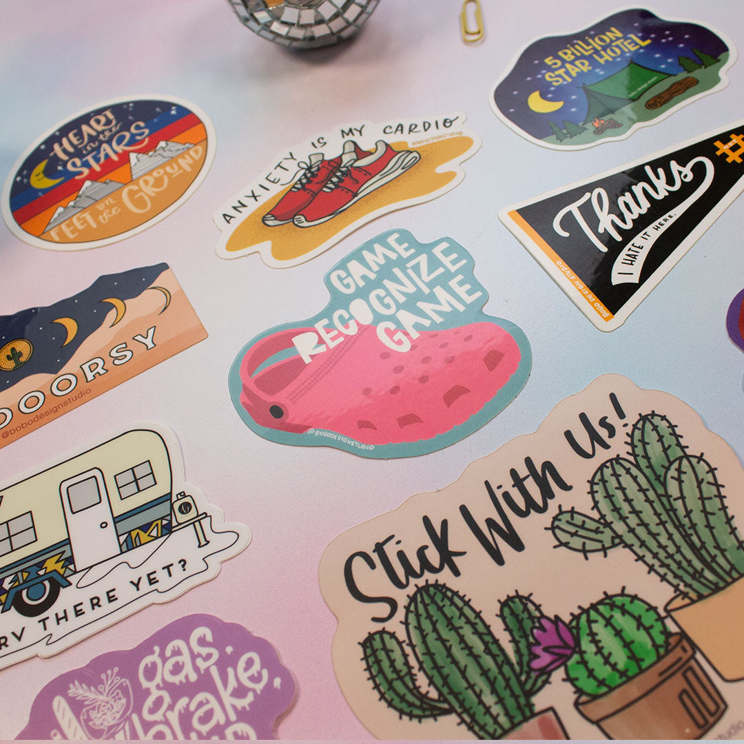 zoomed in image of nine stickers and a mini disco ball and paperclip