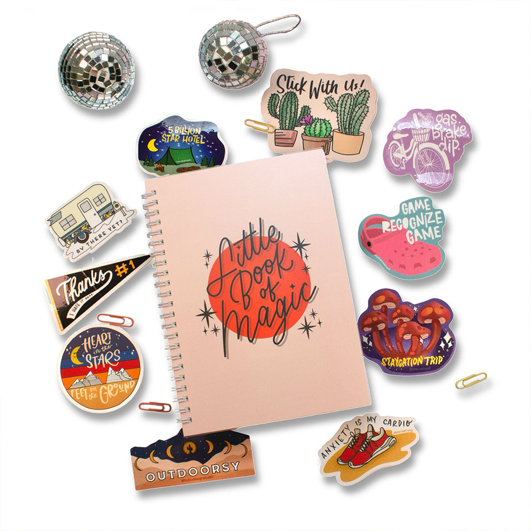 reusable sticker book that says "little book of magic" on the front and ten stickers and four paper clips surrounding the book with two mini disco balls above the book