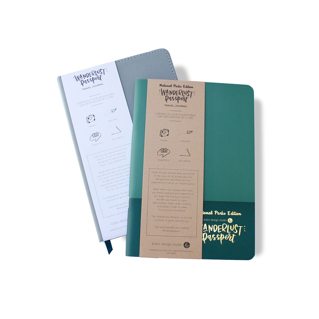a national parks wanderlust passport on top of a grey wanderlust passport