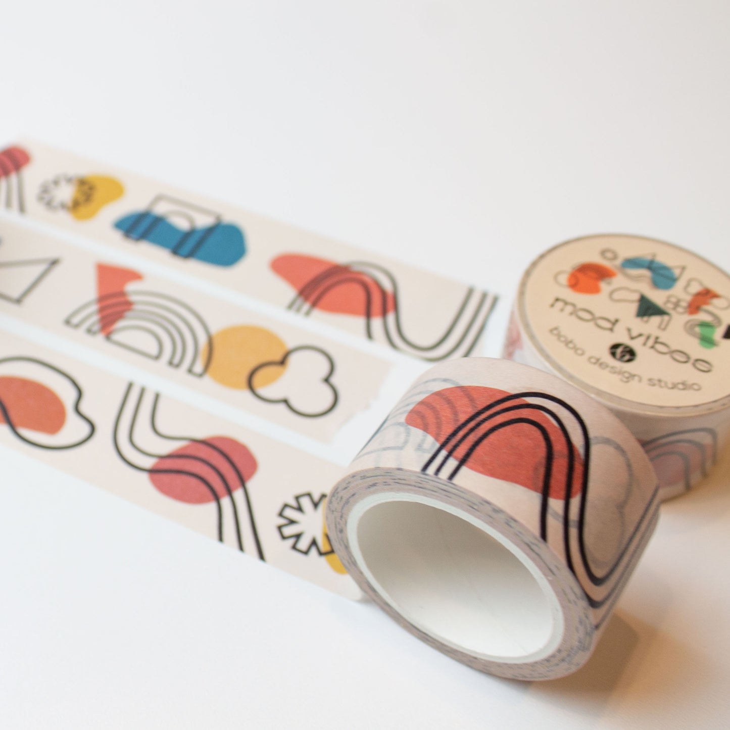 three mod vibes washi tape rolled out one inch wide with abstract lines and shapes on a light beige background