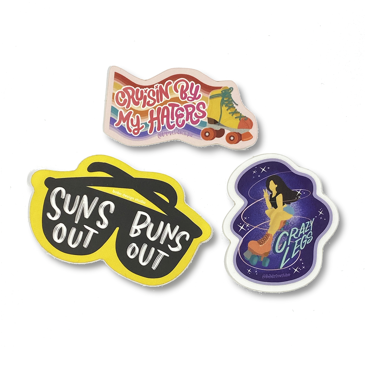 roller skating sticker sheet stickers. black sunglasses that says "suns out buns out on each lens, a roller skate with a rainbow background that says cruisin by my haters and a women in rollerskates that says "crazy legs"