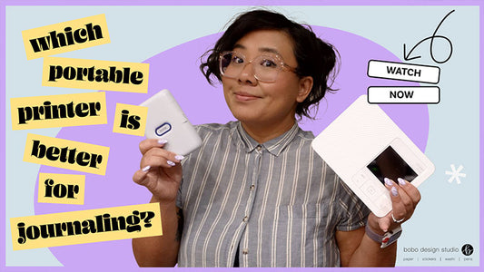 graphic of angie holding up two printers, one is the instax portable printer, and the other is the canon selphy. the graphic reads "which portable printer is better for journaling?"