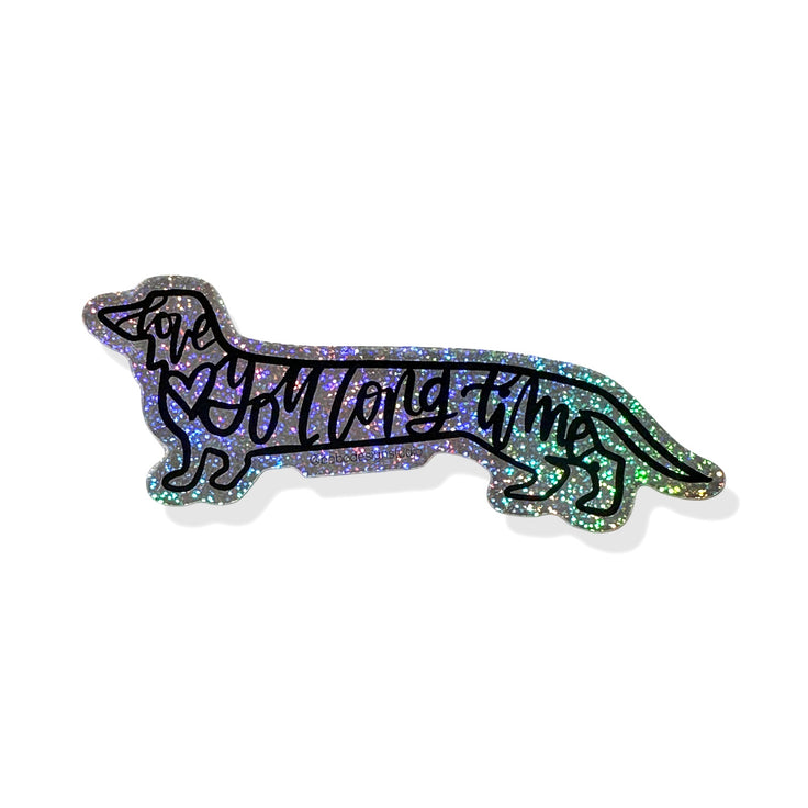 love you long time sparkly sticker. outline of a winer dog with the words "love you long time" written in cursive with black lettering and a small black heart outline inside of the body of the dog