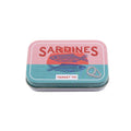 Small metal tin labeled 'Sardines' with fish illustrations on a white background