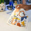 someone holding the mid mod super cloth in a kitchen next to a sink 