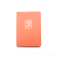 The A5 bobo BuJo Dot Grid Journal in "Tangerine" orange. A gold foil illustration of mandarin tree leaves and a sun is stamped on the front cover. A matching orange elastic closure is holding the journal closed.