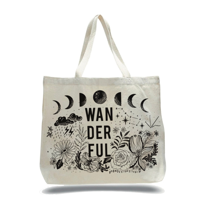 large canvas tote white cream color with black decals such as the moon cycle, flowers, stars, and clouds with the word "wanderful" spelled out 