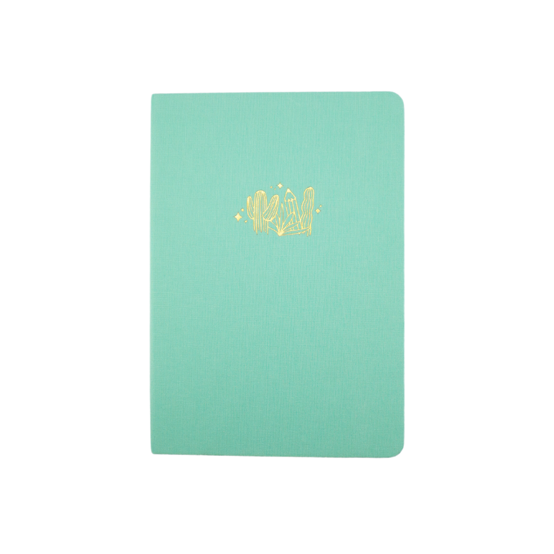 The A5 bobo Lined Journal "Pencil Garden" with a light mint green linen cover. A gold foil illustration of cactus and pencils is stamped onto the front cover. 
