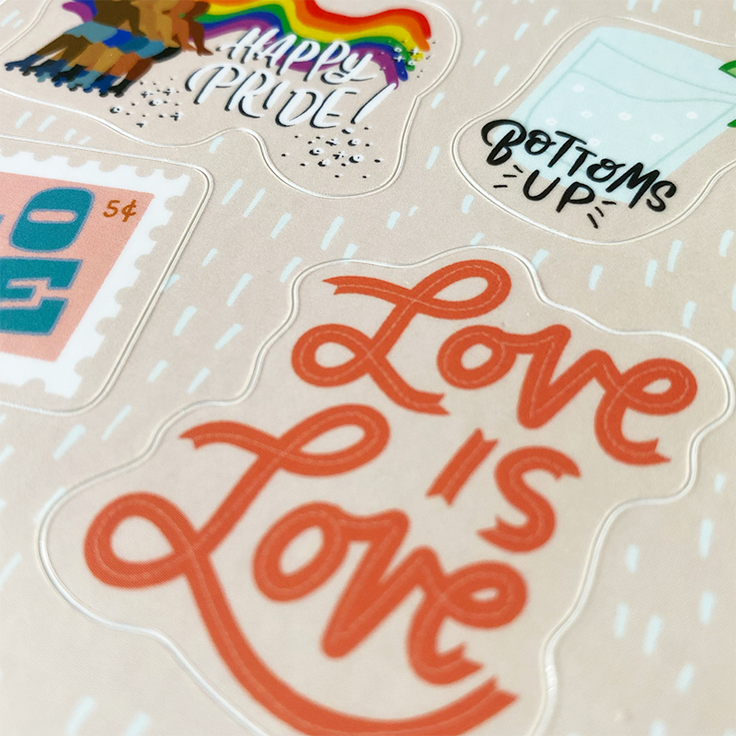 zoomed in image of pride sticker sheet showing a sticker written love is love in red letters