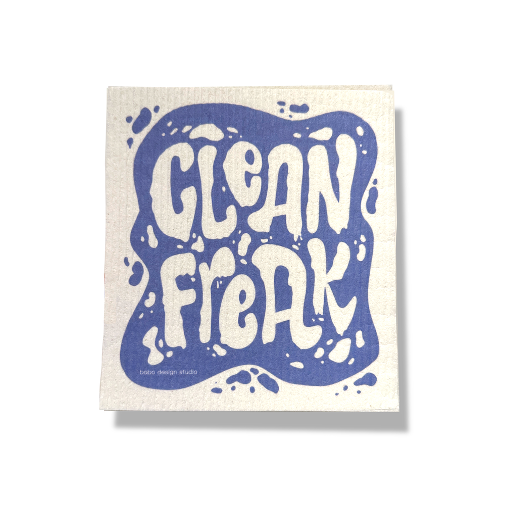 Super Cloth in "Clean Freak" on a white background. Sponge cloth is 6.5x8 inches and has a wrinkled texture. The sponge cloth is printed with a blue organic shaped blob that looks like a spilled liquid. The words "Clean Freak" are printed in a white organic blob text on the blue background. The text is surrounded by smaller blob shapes in blue and white.