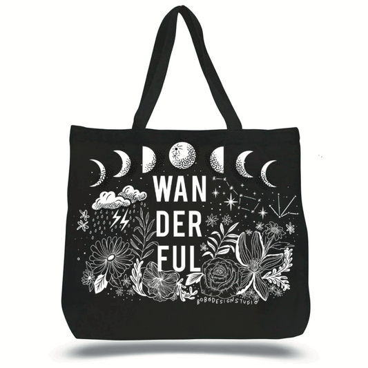 Large black colored canvas tote bag with the word, wanderful, and an image of moon phases, stars, clouds, rain, and flowers printed on the side in white.