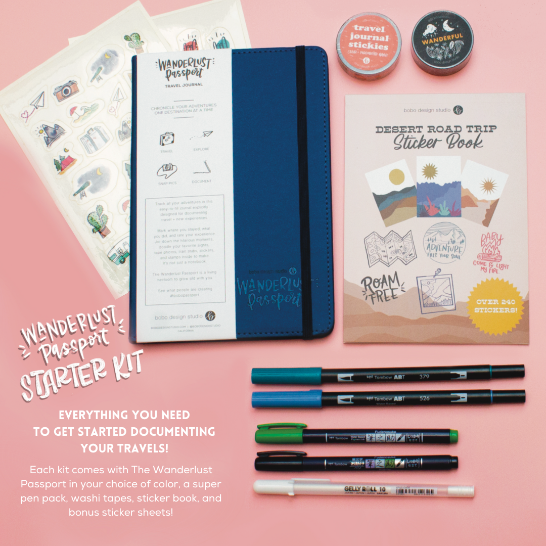 blue wanderlust passport on top of two sticker sheets next to two washi tapes and a sticker book. Underneath the passport is five various pens 