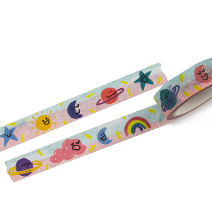 friendly skies washi tape rolled out it has a blue pink background with stars, suns, moons, planets, rainbows, and clouds. they each have a different expression