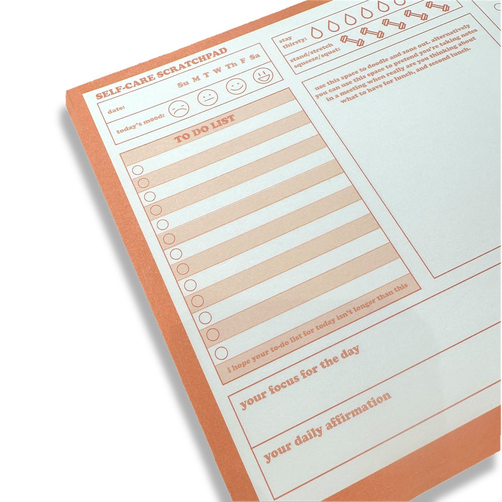 zoomed in image of left side of orange self care scratch pad 