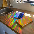 a sun catcher projecting onto two wanderlust passports on a counter 